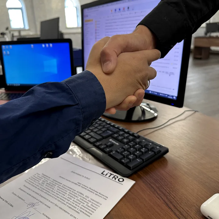 Клиент и специалист LiTRO завершают оформление документов рукопожатием